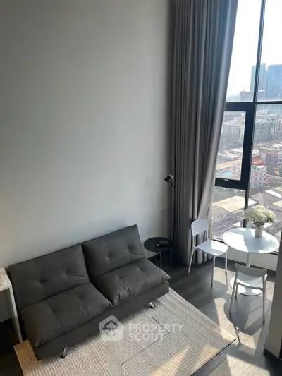 Modern living room with high ceiling and large window offering city views