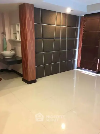 Spacious modern room with stylish wall paneling and glossy tiled floor