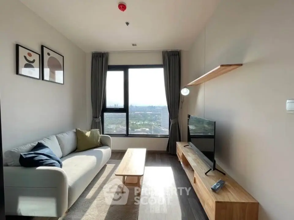 Modern living room with large window and stylish furniture offering a stunning city view.