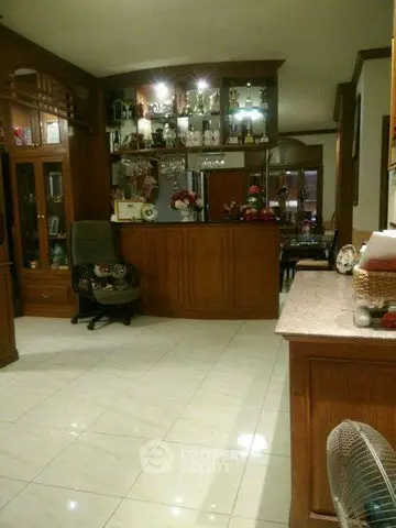 Spacious living room with elegant wooden cabinetry and tiled flooring