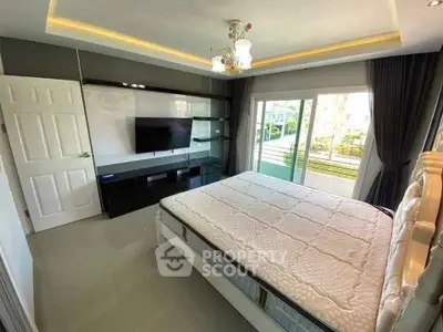 Modern bedroom with large window and sleek TV setup, offering a bright and inviting atmosphere.