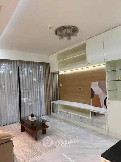 Modern living room with sleek furniture and large windows for natural light.