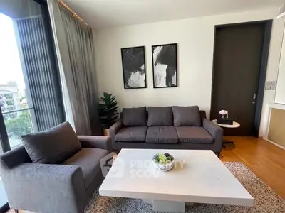 Modern living room with stylish furniture and large windows offering natural light.