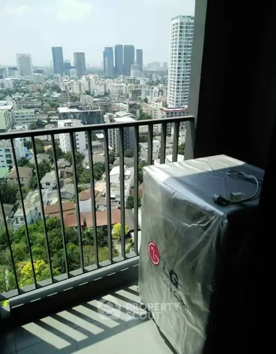 High-rise balcony with cityscape view and covered appliance