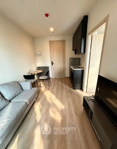 Modern compact living room with kitchenette and stylish furniture in a cozy apartment.