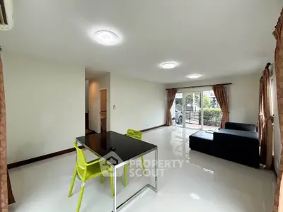 Spacious modern living room with sleek furniture and large windows offering natural light.