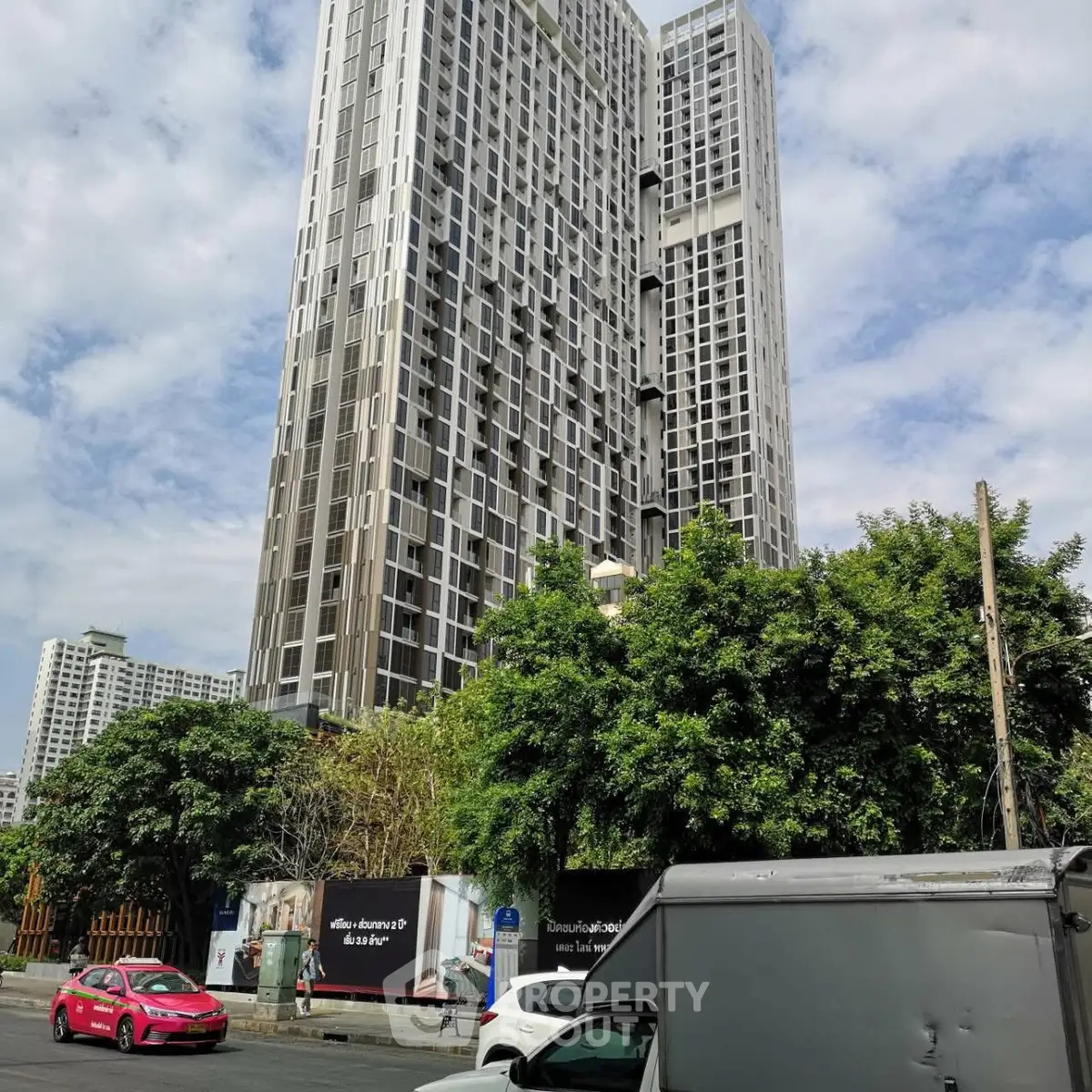 Stunning high-rise building with modern architecture and lush greenery in urban setting.
