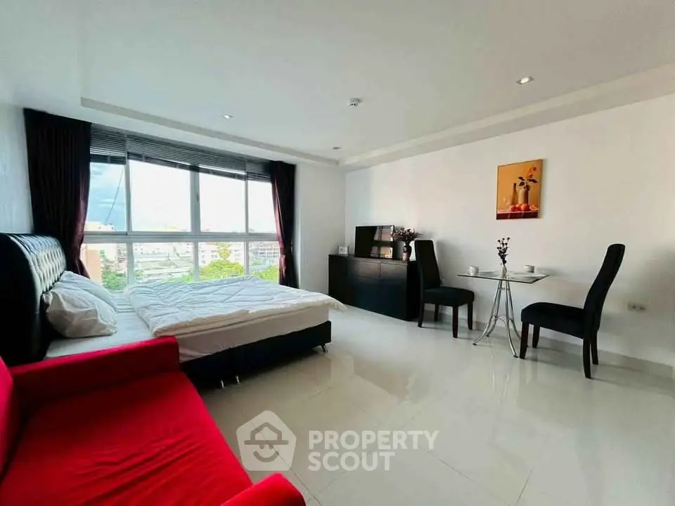 Spacious modern bedroom with large window and elegant furnishings