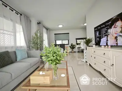 Spacious living room with modern decor and large TV, perfect for relaxation.