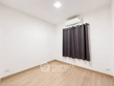 Spacious unfurnished room with wooden flooring and air conditioning, perfect for customization.