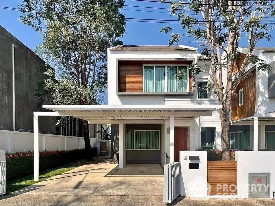 Modern two-story house with carport and stylish facade in a serene neighborhood.