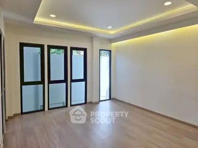 Spacious modern living room with wooden flooring and recessed lighting.