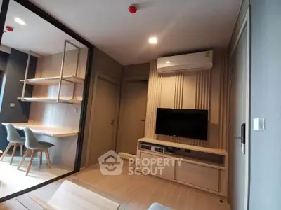 Modern living room with sleek design and built-in TV unit, featuring a cozy workspace and stylish decor.