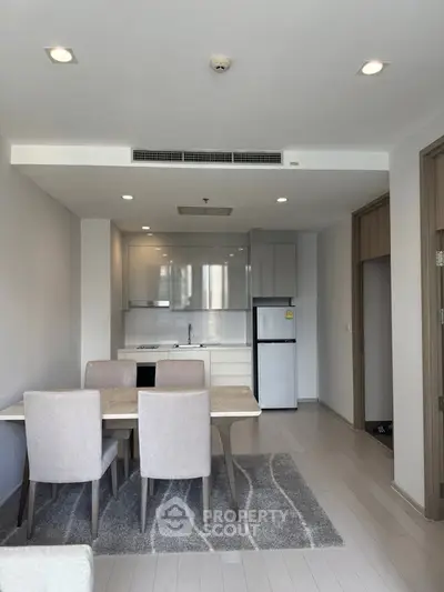 Modern dining area with sleek kitchen in open layout apartment