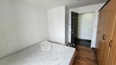 Cozy bedroom with wooden flooring and wardrobe, perfect for a minimalist lifestyle.