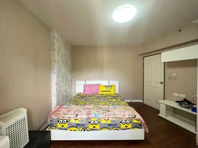 Cozy bedroom with playful decor and ample natural light, perfect for relaxation.