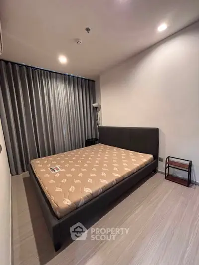 Modern bedroom with stylish bed and floor-to-ceiling curtains in a cozy apartment.