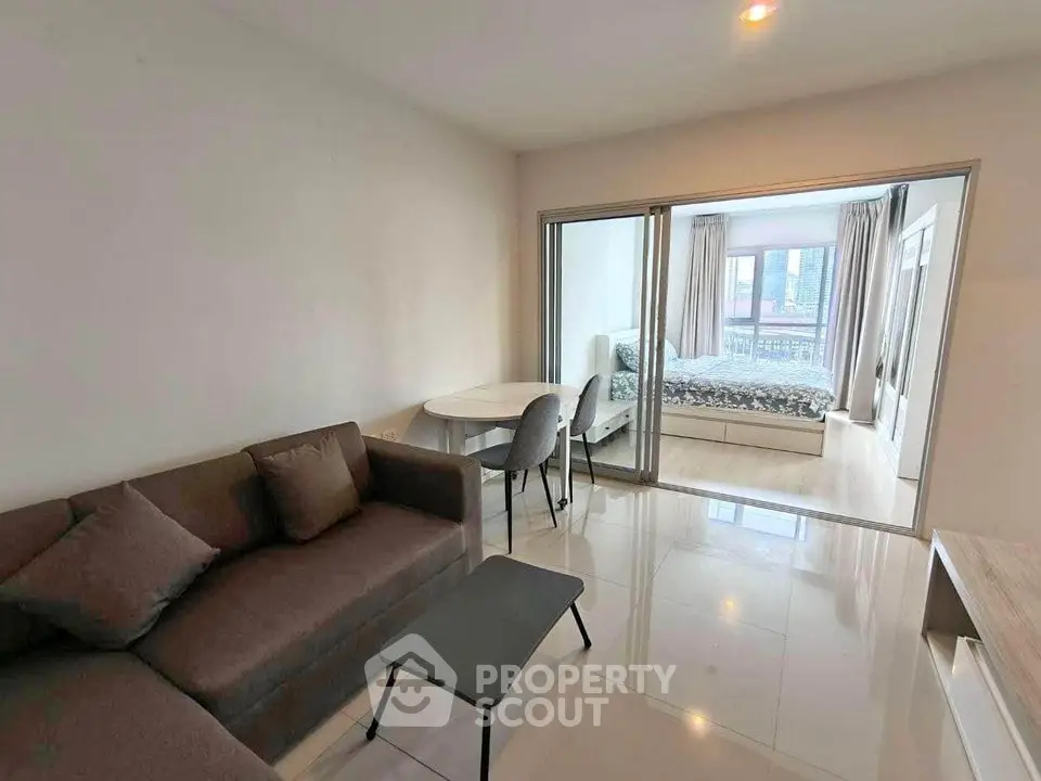Modern apartment with cozy living room and bedroom, featuring sleek furniture and bright interior design.