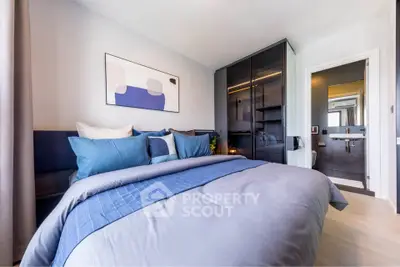 Modern bedroom with stylish decor and ensuite bathroom, featuring a cozy bed and sleek wardrobe.