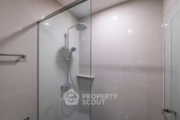 Modern bathroom with sleek glass shower enclosure and chrome fixtures.