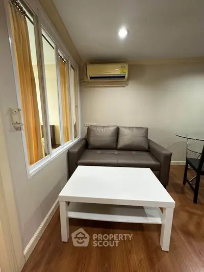 Cozy living room with modern sofa and air conditioning, perfect for relaxation.
