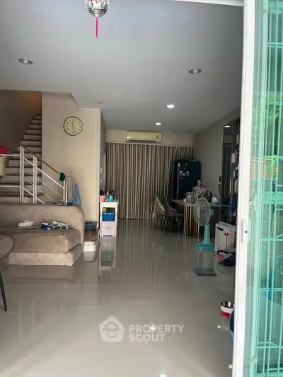 Spacious living room with modern decor and staircase, perfect for family gatherings.