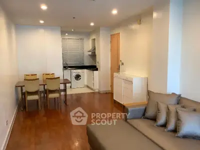 Spacious open-plan living room with modern kitchen and dining area, featuring hardwood floors and cozy seating.