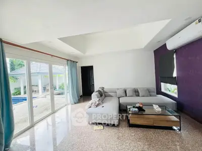 Spacious living room with pool view and modern decor