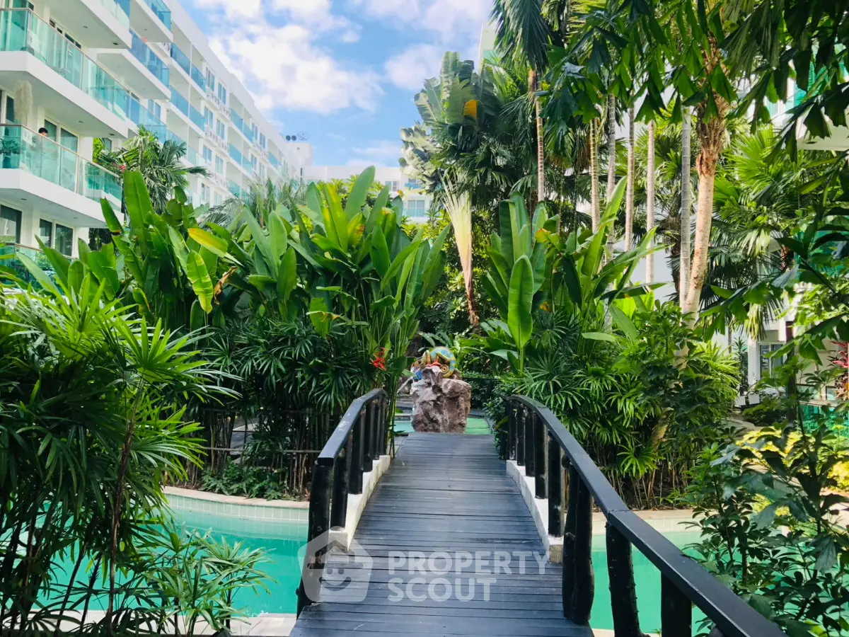 Luxurious tropical garden with pool and modern apartment building