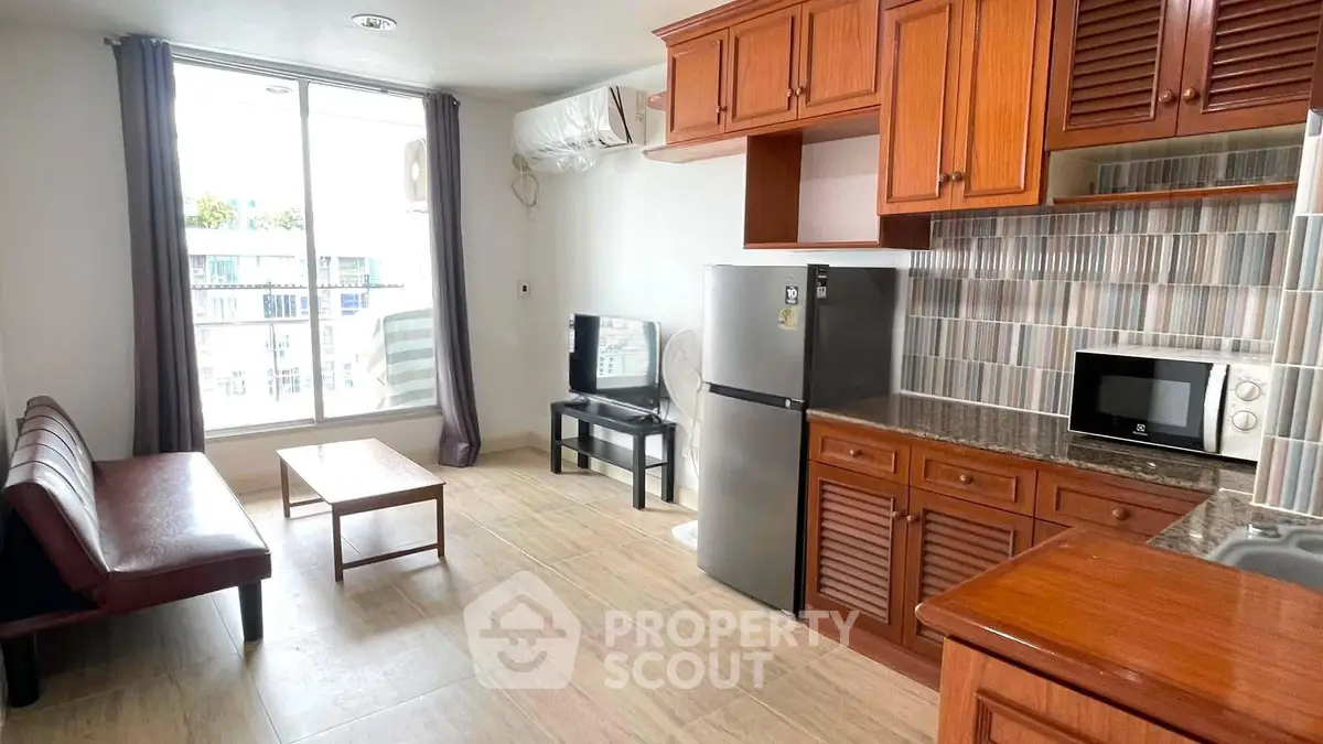 Spacious living room with modern kitchen and large window view