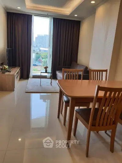 Modern living room with dining area and city view, featuring sleek furniture and natural lighting.