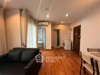 Spacious living room with modern furnishings and hardwood floors in a stylish apartment.