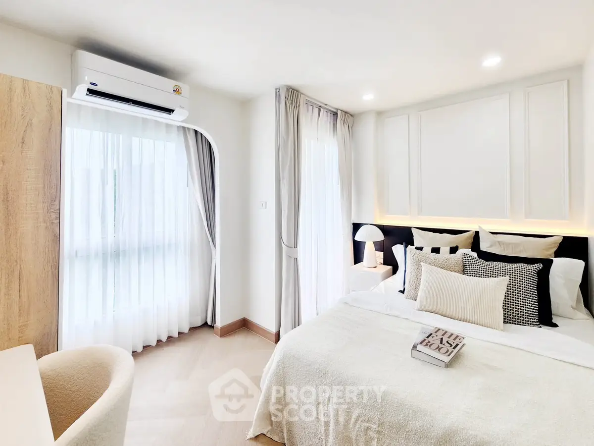 Elegant bedroom with cozy decor and natural light, featuring a stylish bed and modern air conditioning unit.