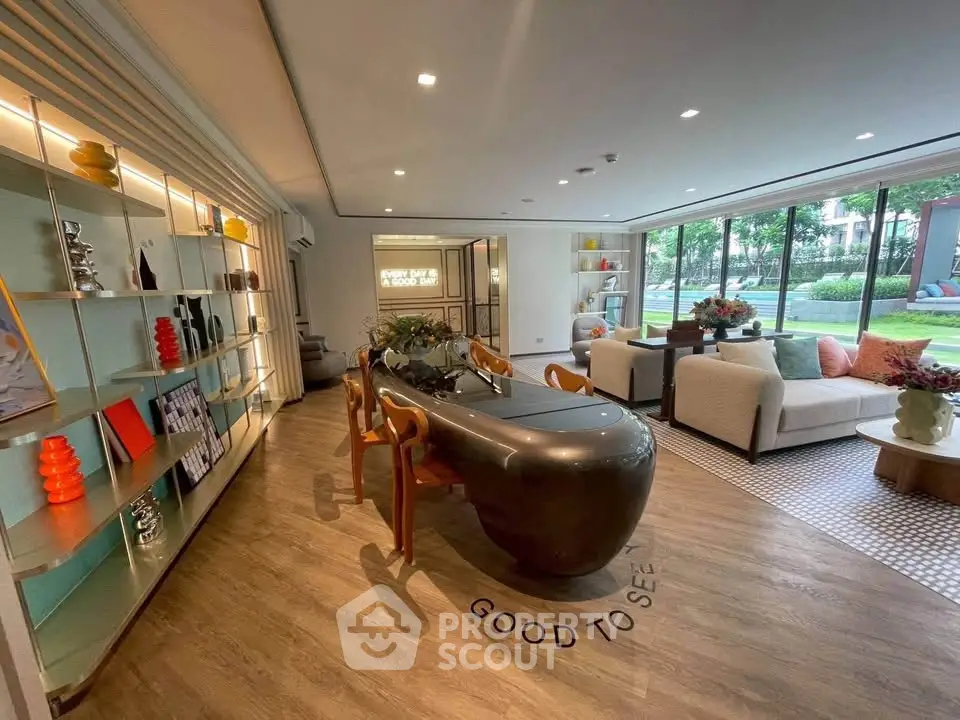 Luxurious living room with modern decor and garden view, featuring elegant furniture and stylish shelving.