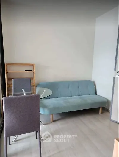 Cozy living room with modern sofa and dining table, perfect for small spaces.