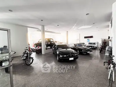 Spacious garage with classic cars and motorcycles, ideal for car enthusiasts.