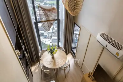 Modern high-rise apartment with stunning city view and elegant dining area.