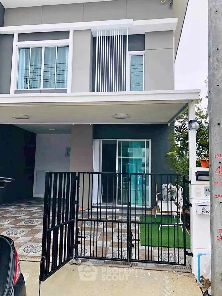 Modern two-story townhouse with gated entrance and stylish facade