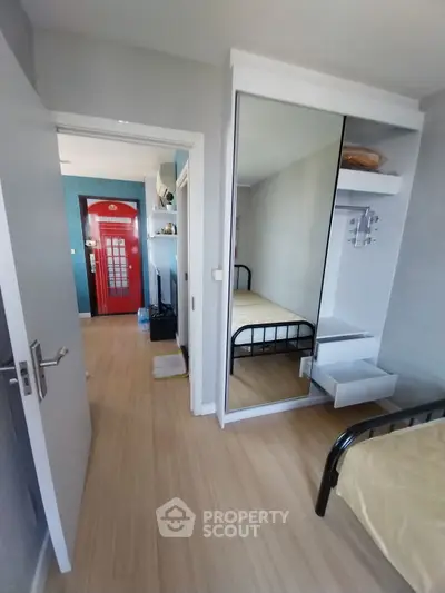 Modern bedroom with mirrored wardrobe and wooden flooring