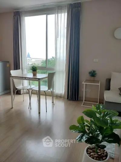 Bright and airy living room with large window and modern decor, perfect for relaxation and entertaining.