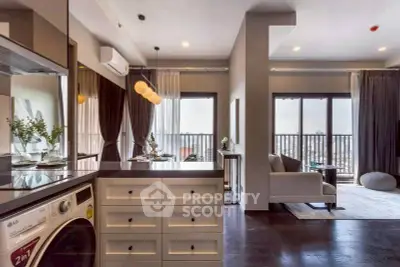 Modern open-plan living room with balcony and washing machine, featuring elegant decor and city views.