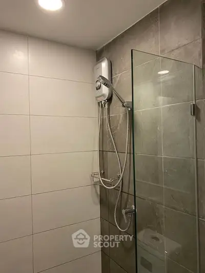 Modern bathroom with sleek shower and glass partition in contemporary home.