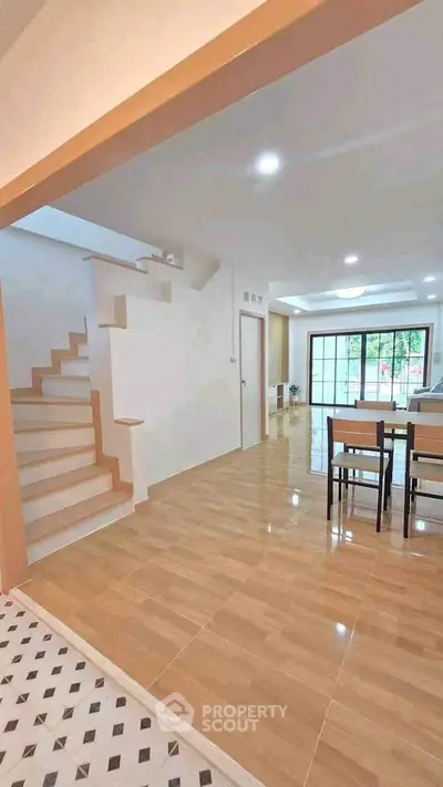 Spacious open-plan living area with modern staircase and dining space.