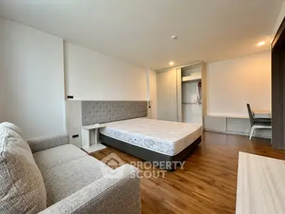 Spacious modern bedroom with wooden flooring and stylish furniture
