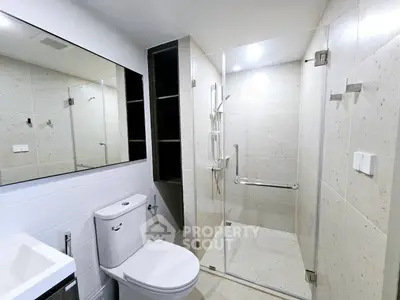 Modern bathroom with glass shower enclosure and sleek fixtures