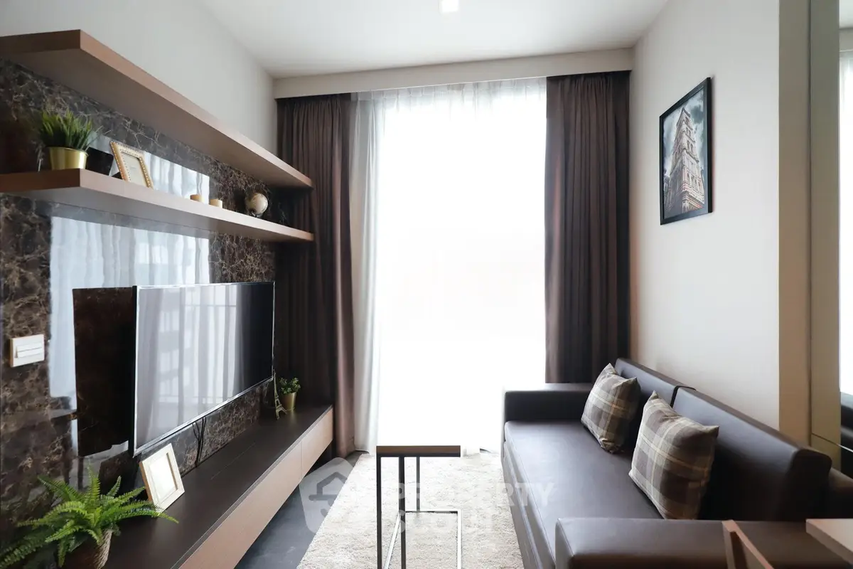 Modern living room with sleek furniture and large window, perfect for relaxation and entertainment.