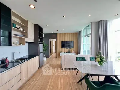 Modern open-plan living room and kitchen with stylish decor and natural light.