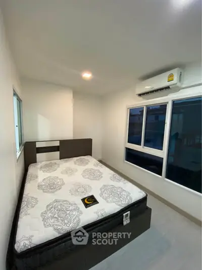 Modern bedroom with large windows and air conditioning in a stylish apartment.
