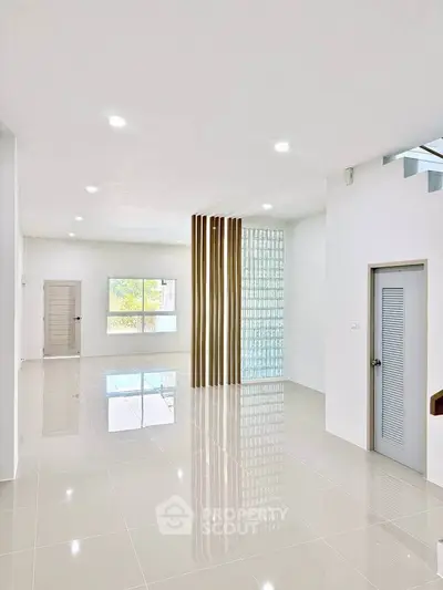 Spacious modern living room with sleek tile flooring and large windows for natural light.