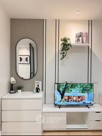 Modern living room with sleek white furniture and wall-mounted TV